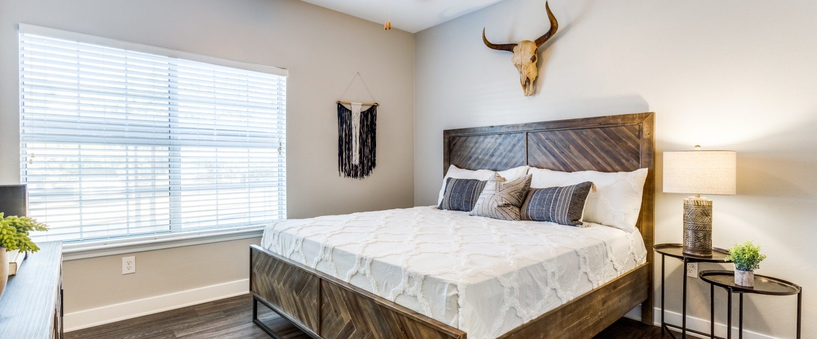 a bedroom with a wooden bed and ceiling fan at The Ellwood at Lake Travis