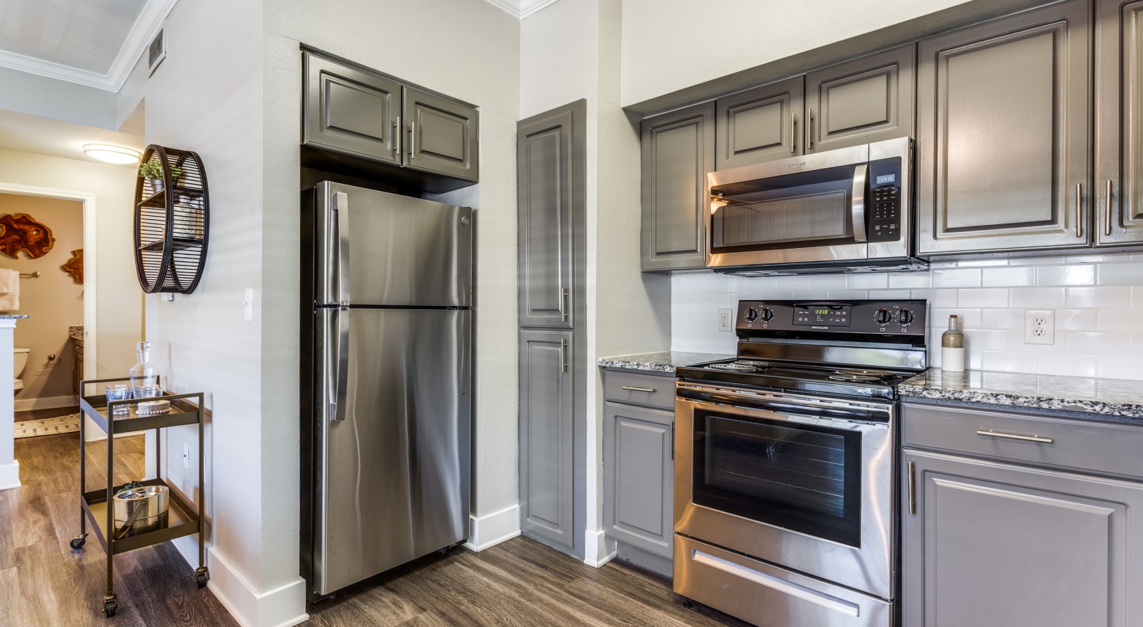 a kitchen with stainless steel appliances and wood floors at The Ellwood at Lake Travis