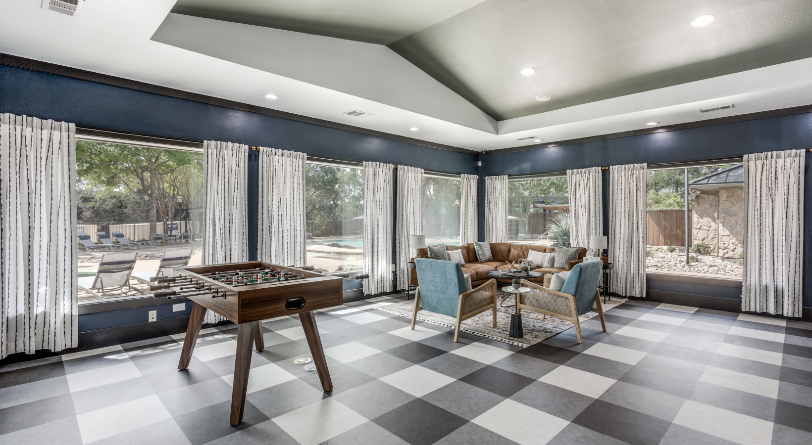 a game room with checkered flooring and a pool table at The Ellwood at Lake Travis