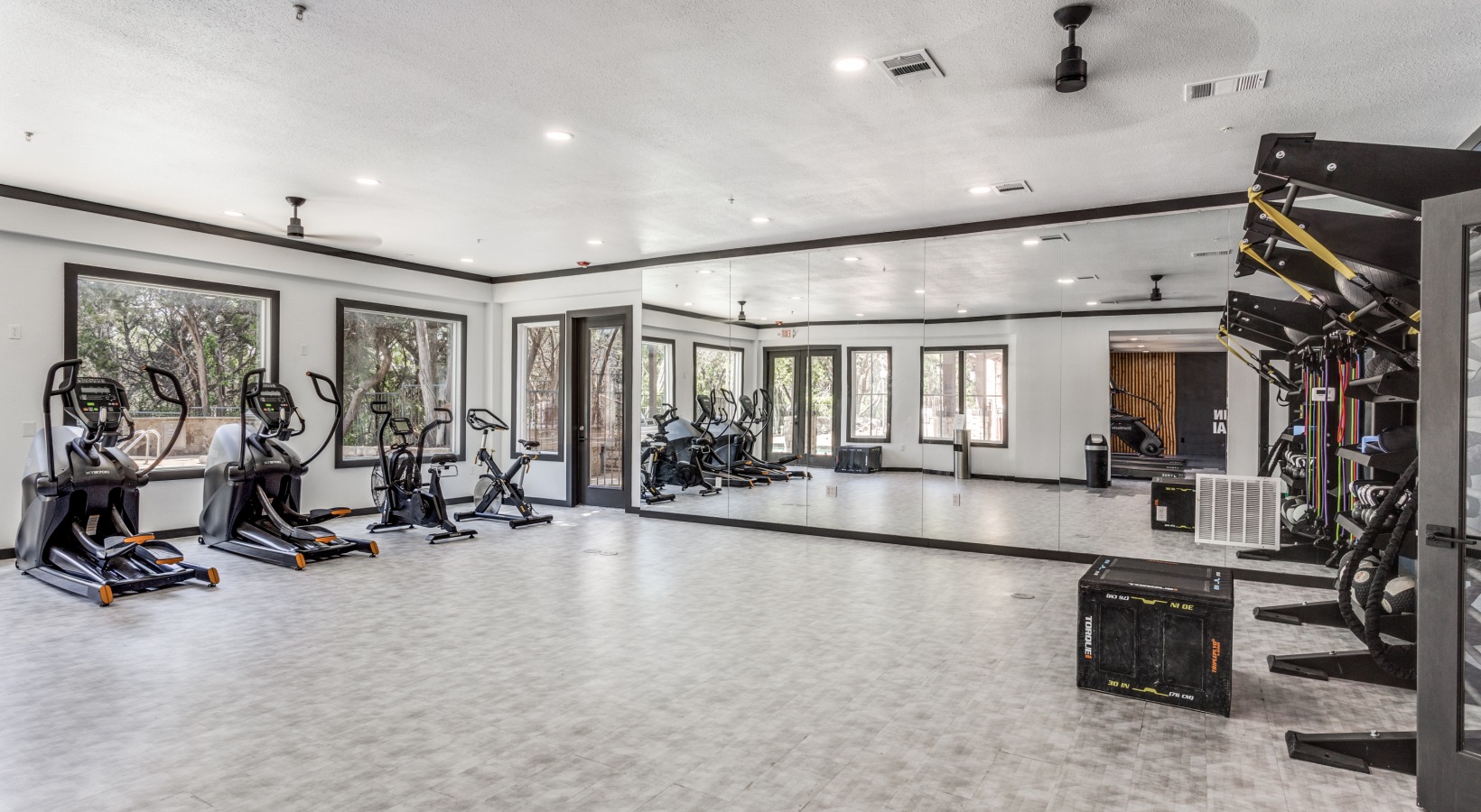 a gym room with exercise equipment and mirrors at The Ellwood at Lake Travis