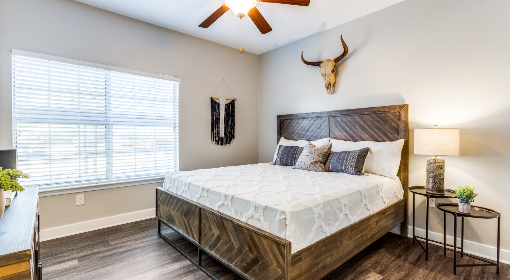 a bedroom with a wooden bed and ceiling fan at The Ellwood at Lake Travis