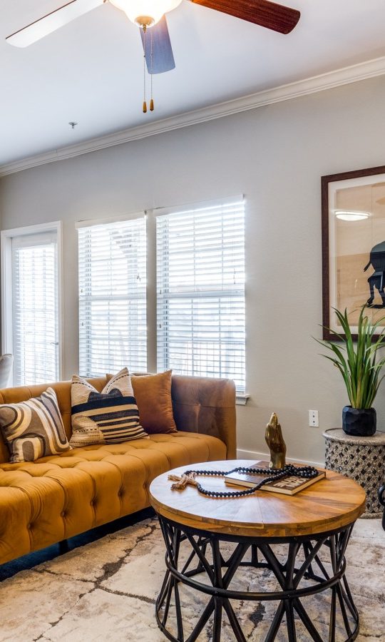 the living room has a brown couch and a yellow rug at The Ellwood at Lake Travis