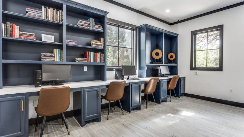a home office with blue cabinets and a desk at The Ellwood at Lake Travis