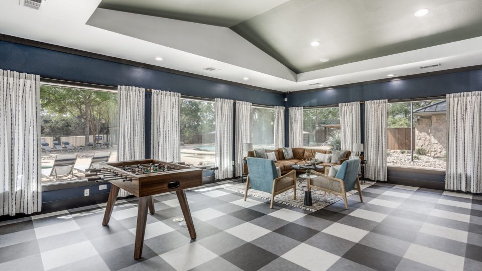 a game room with checkered flooring and a pool table at The Ellwood at Lake Travis